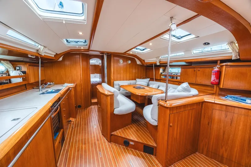  Yacht Photos Pics Interior of 2006 Jeanneau Sun Odyssey 49 yacht with wooden finish and seating area.