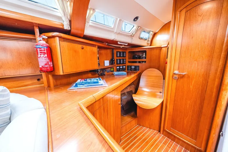  Yacht Photos Pics Interior of 2006 Jeanneau Sun Odyssey 49 sailboat with wooden cabinetry and navigation station.