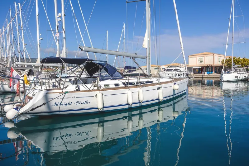  Yacht Photos Pics 2006 Jeanneau Sun Odyssey 49 sailboat docked in a marina, reflecting on calm water.