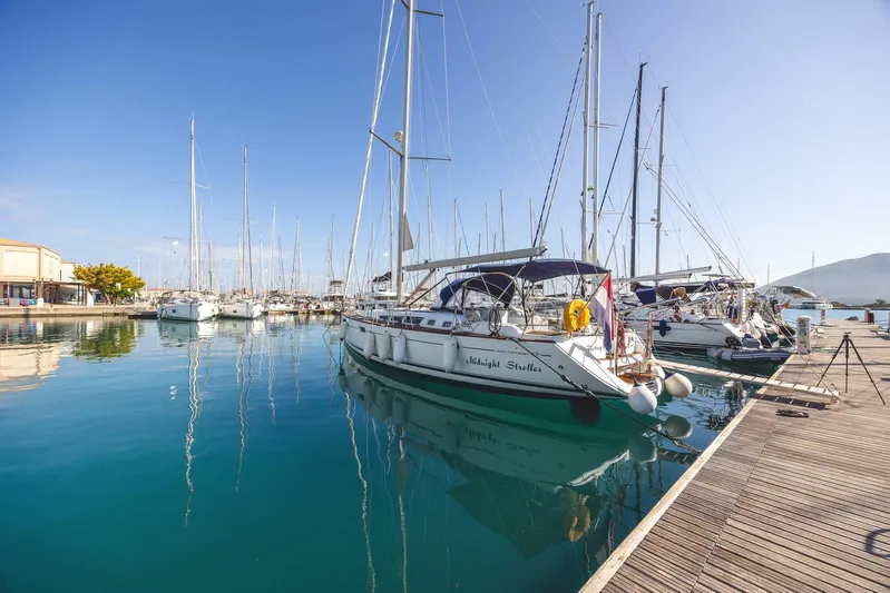  Yacht Photos Pics 2006 Jeanneau Sun Odyssey 49 sailboat docked in a serene marina.