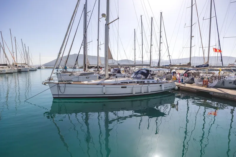  Yacht Photos Pics 2006 Jeanneau Sun Odyssey 49 sailboat docked in a marina, calm water reflections.