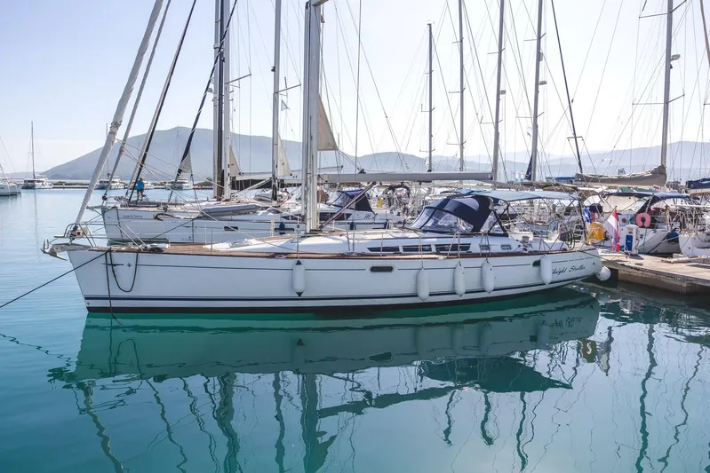  Yacht Photos Pics 2006 Jeanneau Sun Odyssey 49 sailboat docked in a marina, surrounded by other yachts.