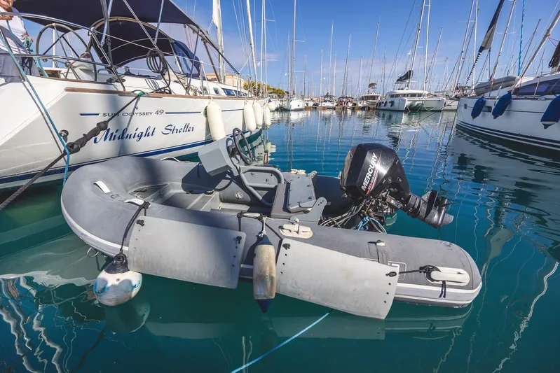  Yacht Photos Pics A 2006 Jeanneau Sun Odyssey 49 yacht docked with an inflatable dinghy in a marina.