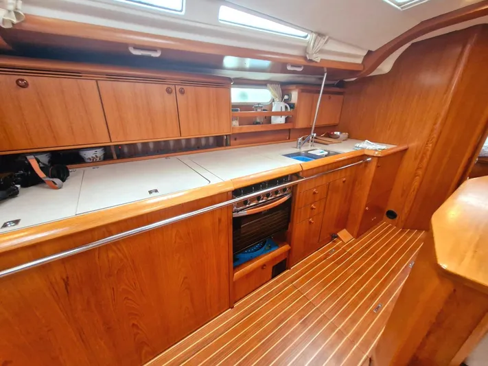  Yacht Photos Pics 2006 Jeanneau Sun Odyssey 49 interior kitchen with wooden cabinetry and modern appliances.