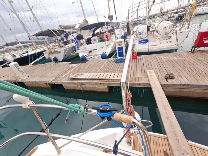  Yacht Photos Pics Docked Jeanneau Sun Odyssey 49 sailboat, 2006 model, in a marina with wooden piers.