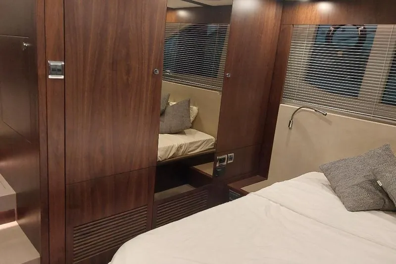 Grata Yacht Photos Pics Luxurious interior of 2022 Fairline Targa 45 GT yacht with wood paneling and cozy bedding.