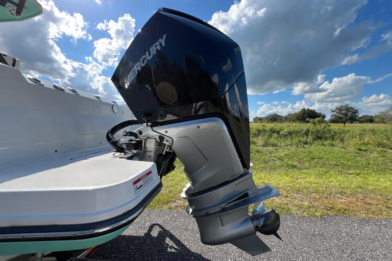  Yacht Photos Pics 2023 Blackfin 272 boat with Mercury outboard motor, set against a scenic landscape.