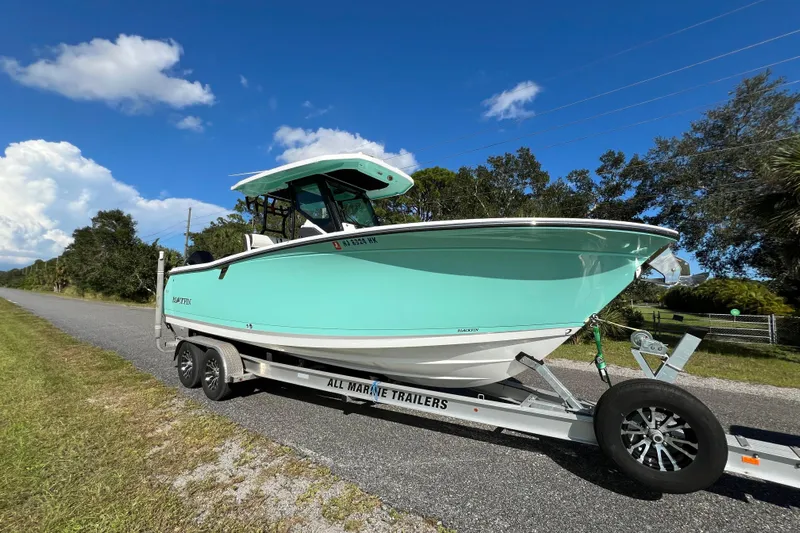  Yacht Photos Pics 2023 Blackfin 272 boat on trailer, parked on roadside under clear blue sky.
