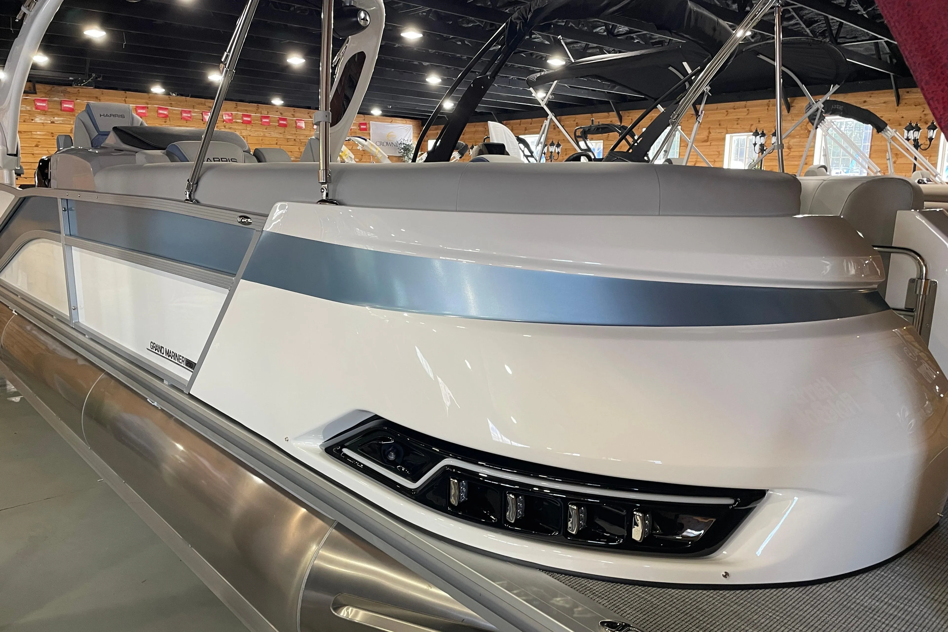 2026 Harris Grand Mariner SEL 250 pontoon boat in showroom, sleek design with modern features.