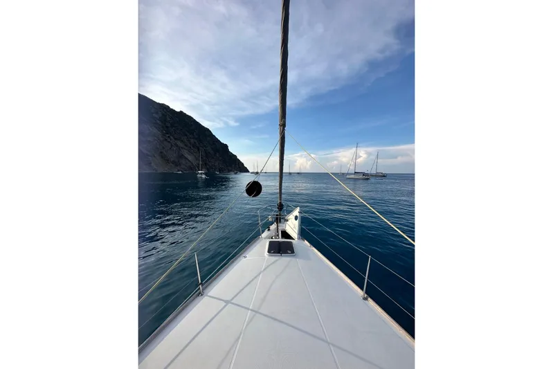 Margaret Yacht Photos Pics Bow view of 2014 Beneteau Oceanis 48 sailing near rocky coastline.