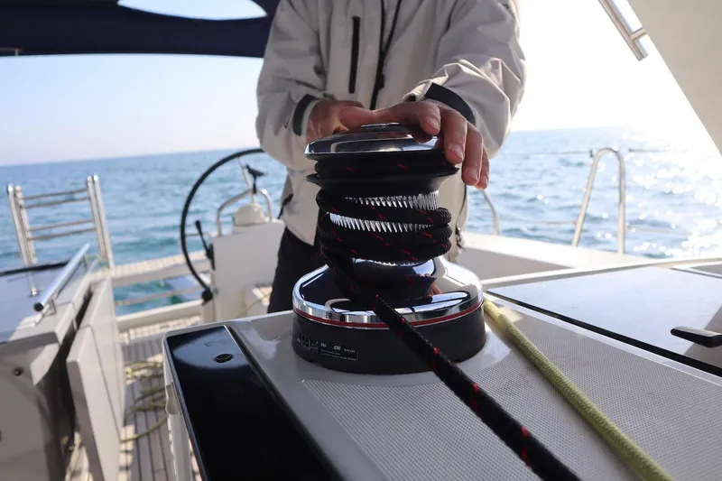 Margaret Yacht Photos Pics Person operating winch on 2014 Beneteau Oceanis 48 sailboat at sea.