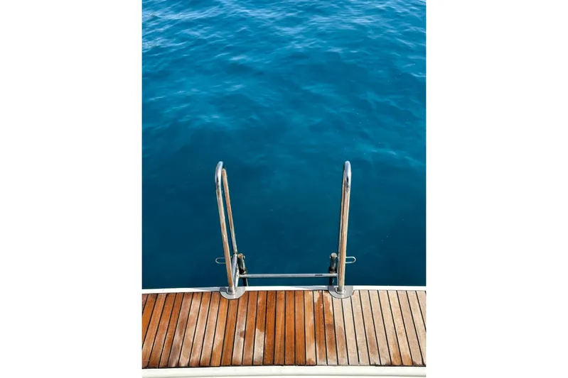 Margaret Yacht Photos Pics Beneteau Oceanis 48 (2014) swim platform with ladder, overlooking calm blue water.