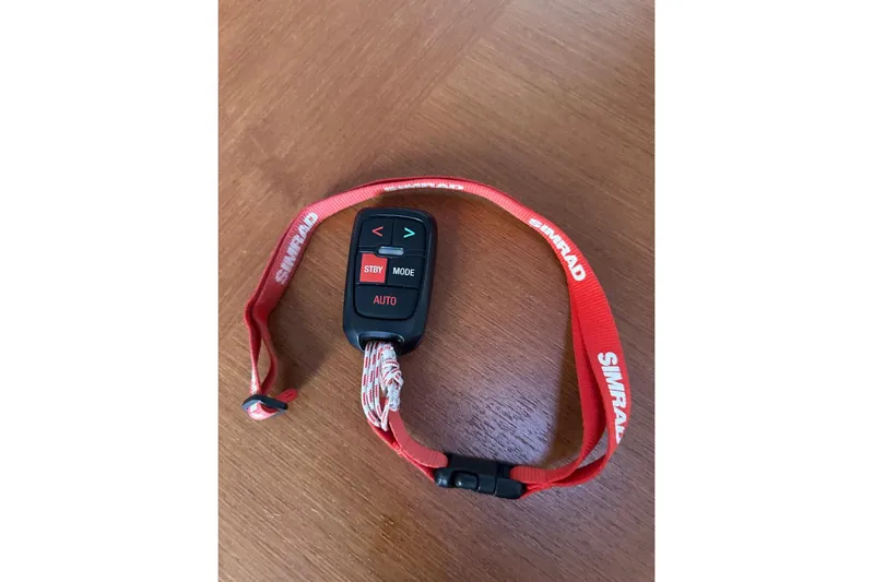 Margaret Yacht Photos Pics Simrad remote control with red lanyard on wooden surface, for Beneteau Oceanis 48, 2014 model.