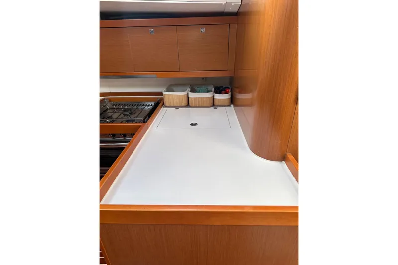 Margaret Yacht Photos Pics Galley kitchen in 2014 Beneteau Oceanis 48 yacht with wooden cabinetry and stove.