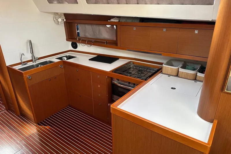 Margaret Yacht Photos Pics Modern kitchen interior of 2014 Beneteau Oceanis 48 yacht with wood cabinetry and appliances.