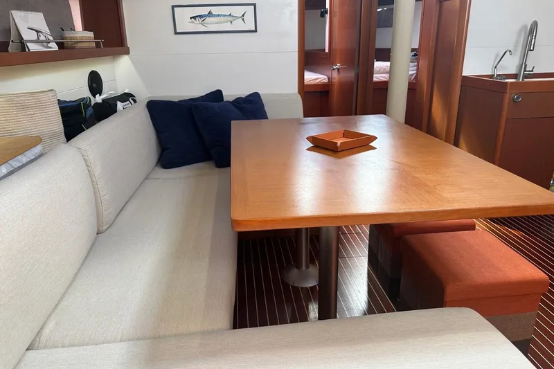 Margaret Yacht Photos Pics Interior of 2014 Beneteau Oceanis 48 yacht with cozy seating and wooden table.