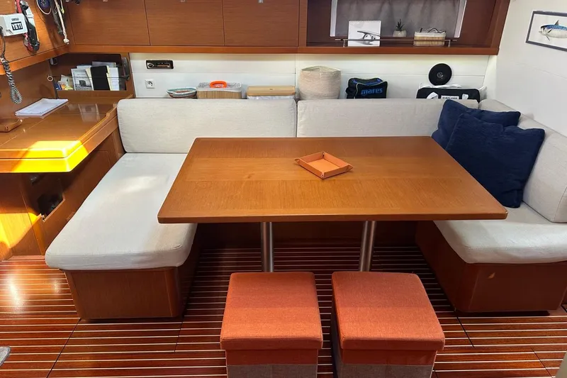 Margaret Yacht Photos Pics Interior of 2014 Beneteau Oceanis 48 yacht with wooden table and seating area.