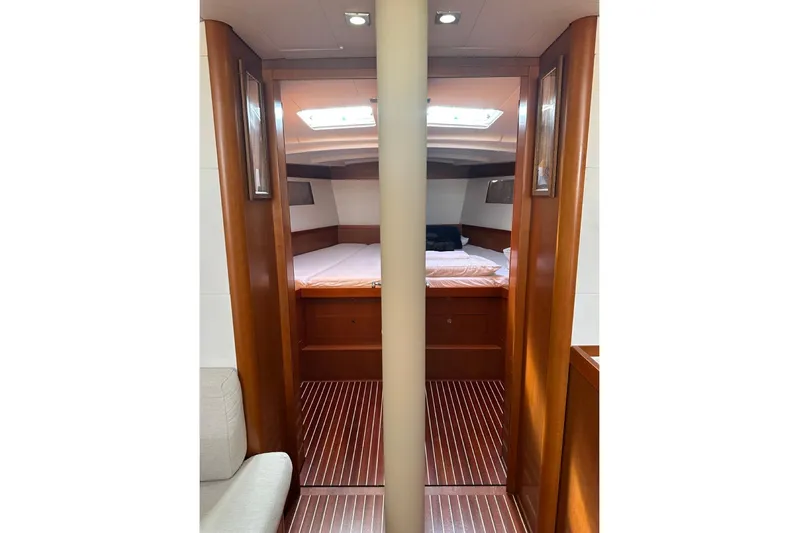 Margaret Yacht Photos Pics Interior cabin of 2014 Beneteau Oceanis 48 yacht with wooden finish and cozy bed.