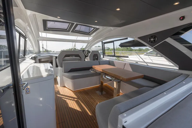  Yacht Photos Pics Luxurious interior of 2025 Beneteau Gran Turismo 45 yacht with modern seating and wooden flooring.