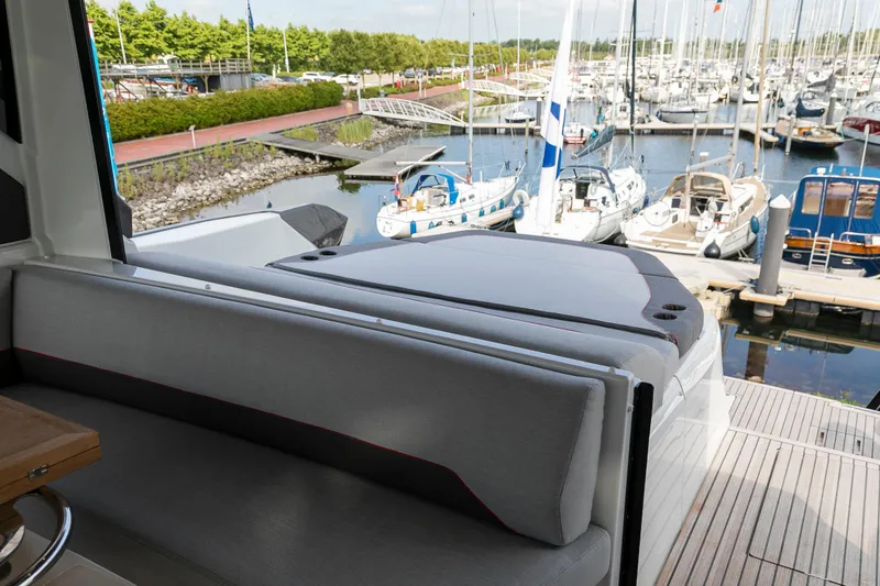  Yacht Photos Pics 2025 Beneteau Gran Turismo 45 yacht interior with marina view, featuring sleek seating and modern design.