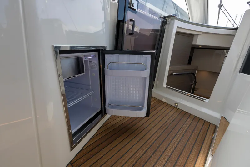  Yacht Photos Pics Open mini fridge on 2025 Beneteau Gran Turismo 45 yacht with teak flooring.
