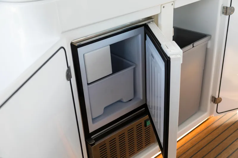  Yacht Photos Pics Open mini fridge on 2025 Beneteau Gran Turismo 45 yacht, showcasing interior storage.