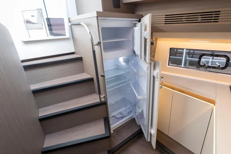  Yacht Photos Pics Modern kitchen interior of 2025 Beneteau Gran Turismo 45 yacht with open refrigerator.