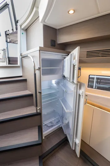  Yacht Photos Pics 2025 Beneteau Gran Turismo 45 yacht interior with open refrigerator and modern design.