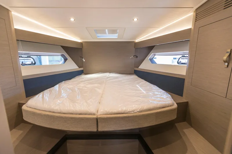  Yacht Photos Pics Luxurious cabin interior of 2025 Beneteau Gran Turismo 45 yacht, featuring modern design and cozy bedding.