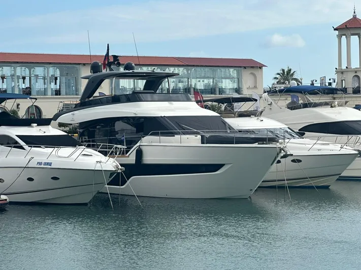  Yacht Photos Pics 2022 Cranchi Sessantasette 67 yacht docked in a marina, surrounded by other boats.