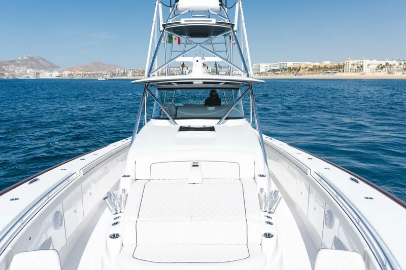 Galati Yacht Sales Trade Yacht Photos Pics 2024 Valhalla Boatworks V-55 cruising on open water near a coastal city.