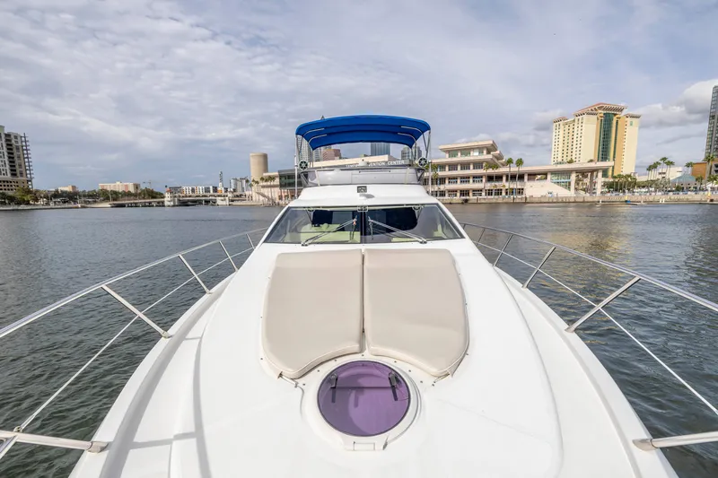 Liquidity Yacht Photos Pics 2012 Azimut 48 Flybridge yacht on calm waters with cityscape background.