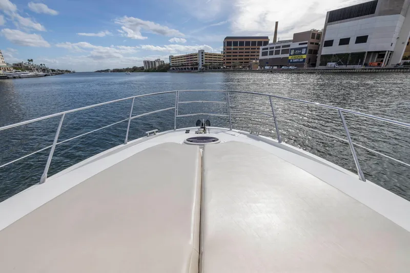 Liquidity Yacht Photos Pics Bow view of 2012 Azimut 48 Flybridge yacht on calm waters near urban buildings.