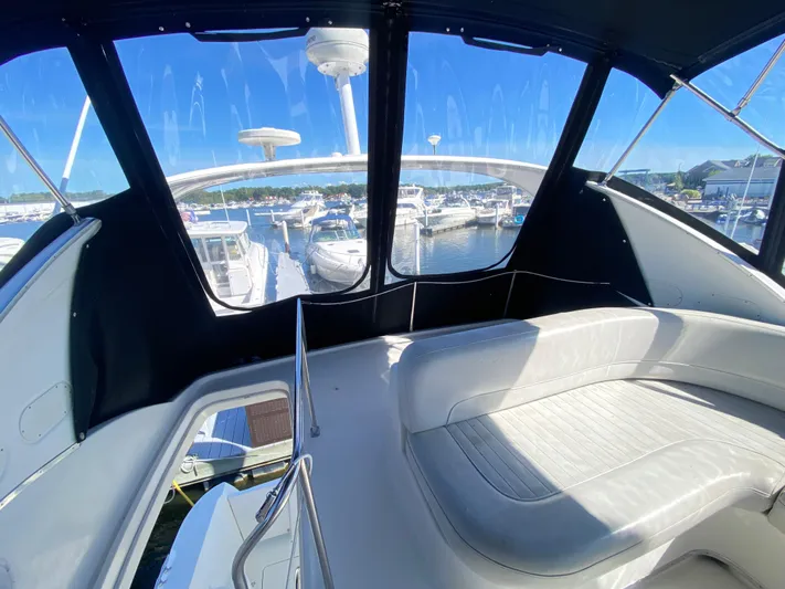  Yacht Photos Pics 2004 Meridian 381 Sedan interior with marina view, featuring white seating and large windows.