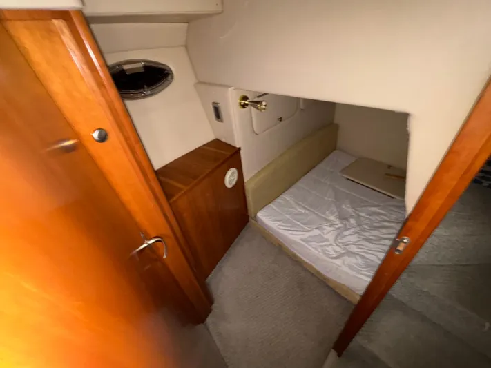  Yacht Photos Pics 2004 Meridian 381 Sedan cabin interior with bed, wooden cabinetry, and porthole window.