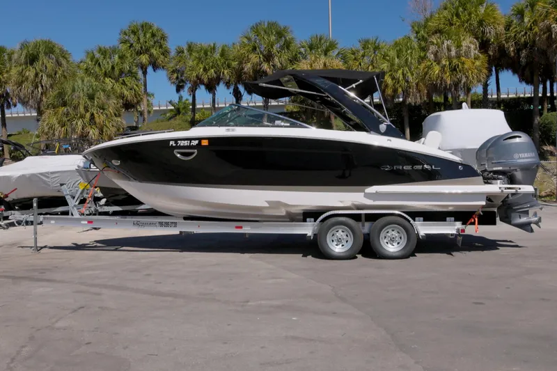  Yacht Photos Pics 2017 Regal 29 OBX boat on trailer, parked with palm trees in the background.