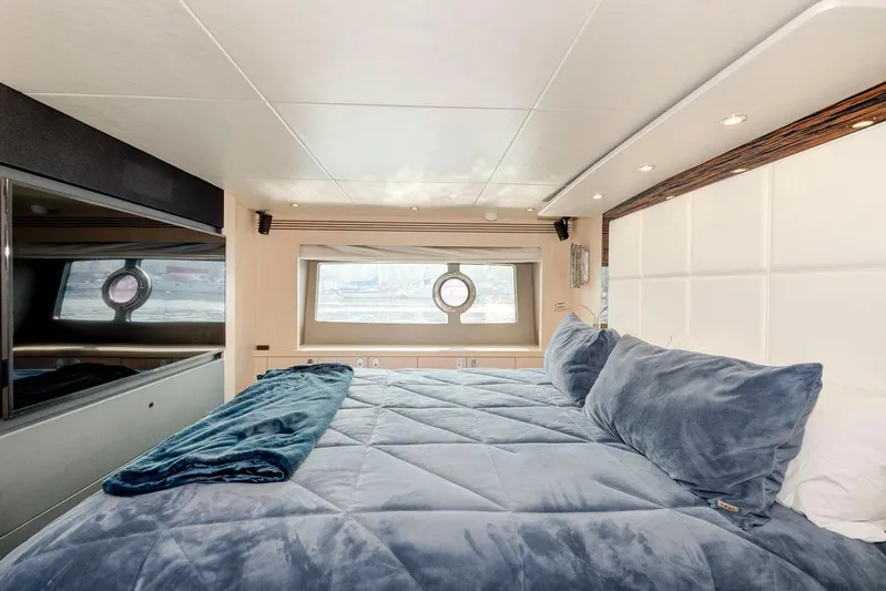 Mojo Risin' Yacht Photos Pics Luxurious bedroom interior of 2017 Sunseeker 75 Yacht with plush bedding and porthole window.