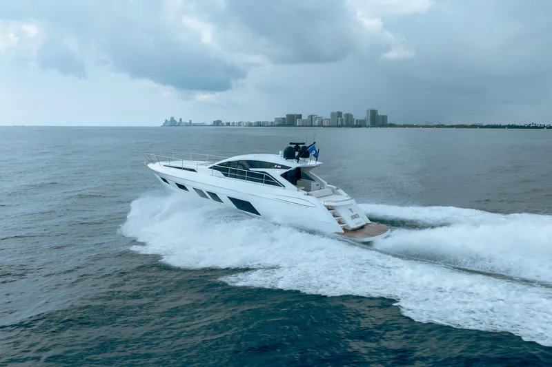 Juice Yacht Photos Pics 2019 Filippetti S55 yacht cruising on open water near a city skyline.