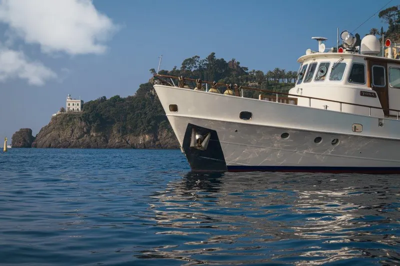 Yona Yacht Photos Pics 1981 Vripack Doggersbank 20 yacht on calm water near rocky coastline and lighthouse.