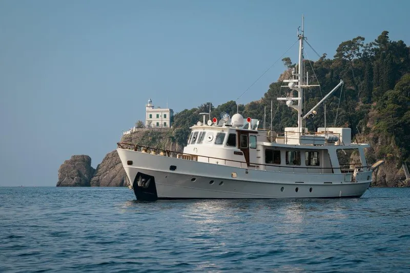 Yona Yacht Photos Pics Classic 1981 Vripack Doggersbank 20 yacht near rocky coastline and lighthouse.