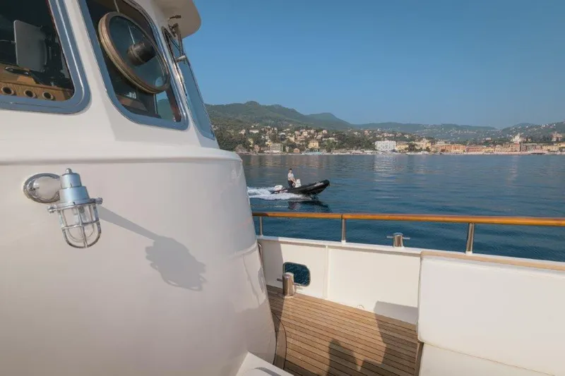 Yona Yacht Photos Pics 1981 Vripack Doggersbank 20 yacht with scenic coastal view and small boat nearby.