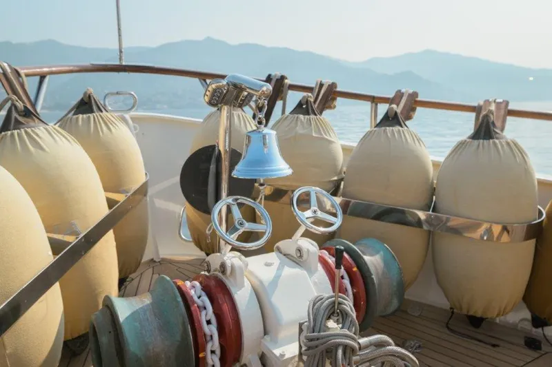 Yona Yacht Photos Pics Deck of 1981 Vripack Doggersbank 20 yacht with fenders and bell, scenic mountain view.