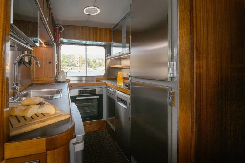 Yona Yacht Photos Pics Cozy kitchen interior of 1981 Vripack Doggersbank 20 yacht with wooden cabinetry and modern appliances.