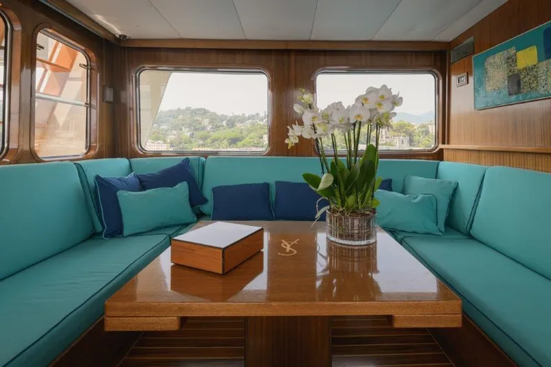 Yona Yacht Photos Pics Luxurious interior of 1981 Vripack Doggersbank 20 yacht with teal seating and floral centerpiece.