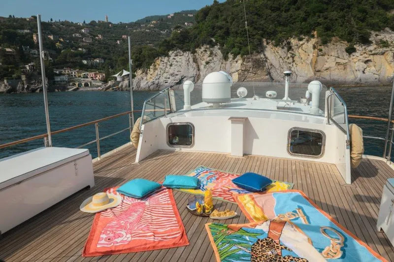 Yona Yacht Photos Pics Deck of 1981 Vripack Doggersbank 20 yacht with colorful towels and scenic coastal view.