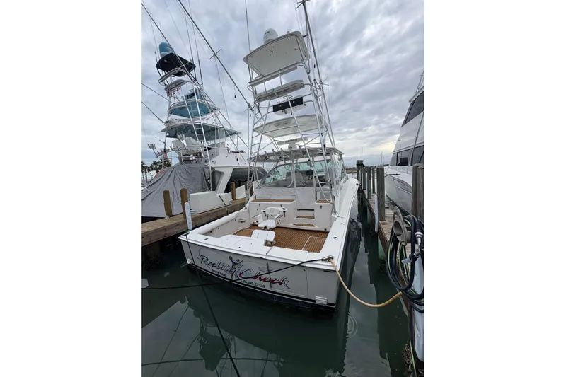 Reelity Check Yacht Photos Pics 2004 Cabo 40 Hardtop Express docked, featuring a spacious deck and fishing tower.