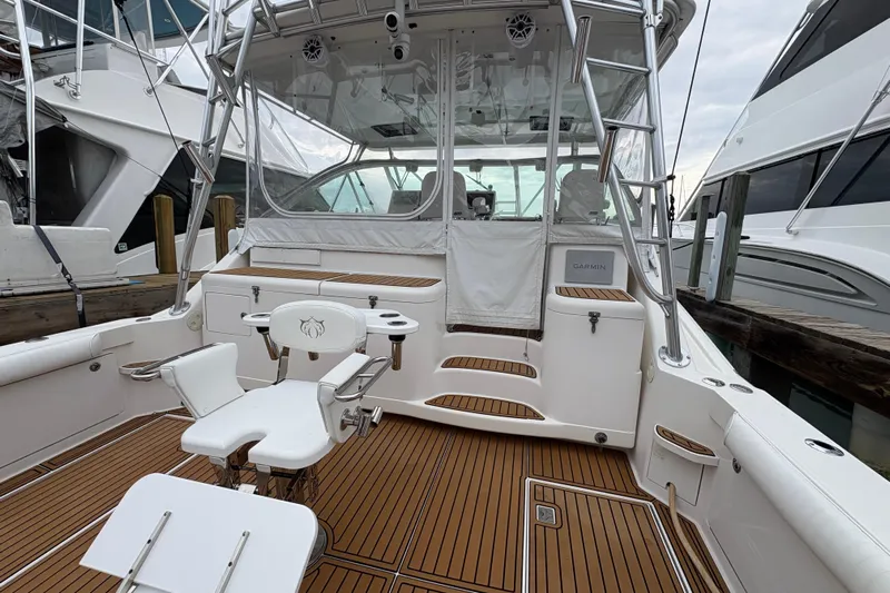 Reelity Check Yacht Photos Pics 2004 Cabo 40 Hardtop Express boat with teak deck and fishing chair in marina.