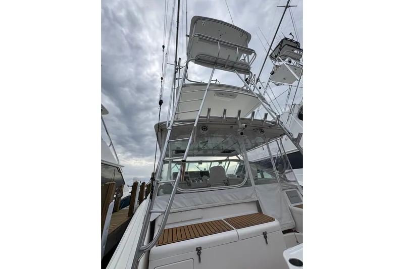 Reelity Check Yacht Photos Pics 2004 Cabo 40 Hardtop Express boat with tower, docked under cloudy skies.