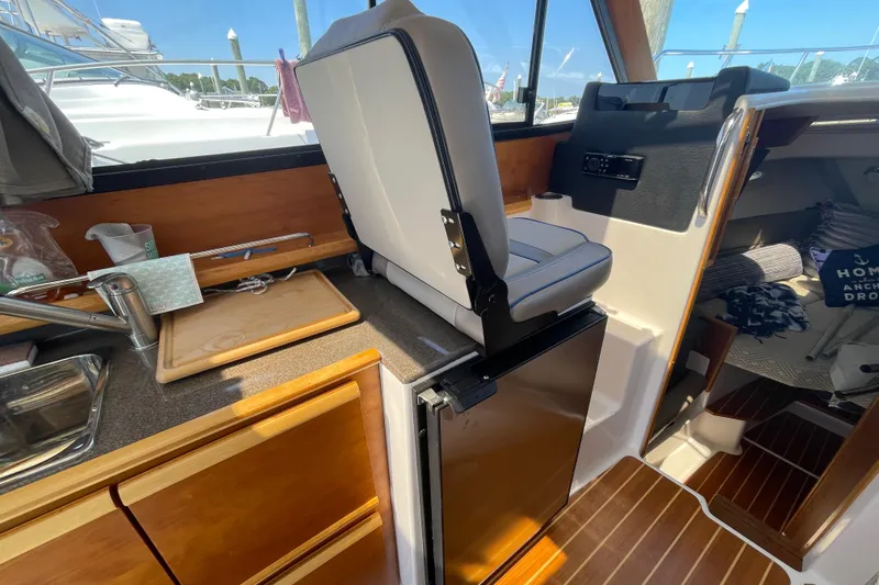  Yacht Photos Pics 2019 Cutwater C-28 boat interior with kitchenette, cutting board, and seating.