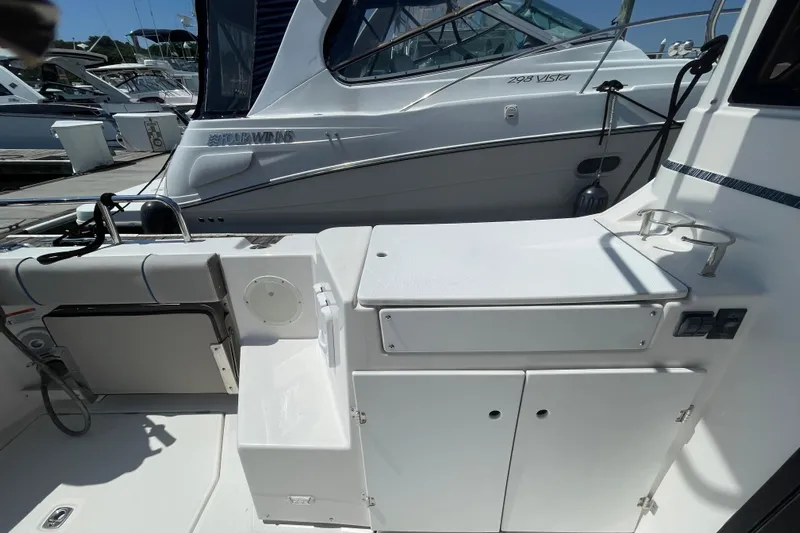  Yacht Photos Pics 2019 Cutwater C-28 boat interior with seating and storage, docked alongside other vessels.